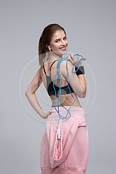 Smiling sporty woman holding skipping rope