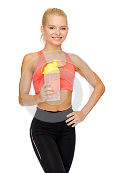 Smiling sporty woman with protein shake bottle