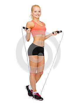 Smiling sporty woman with with skipping rope