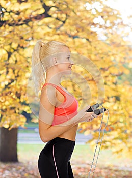 Smiling sporty woman with skipping rope