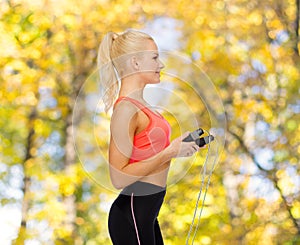 Smiling sporty woman with skipping rope