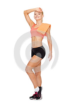 Smiling sporty woman with towel wiping of sweat