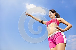 Smiling sporty woman watching and pointing far away