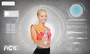 Smiling sporty woman with water bottle and towel