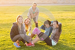 Smiling sporty women doing sit ups during fitness class