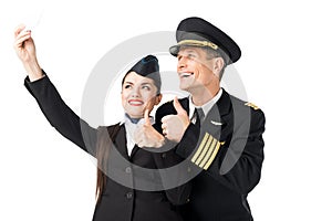 Smiling stewardess and pilot taking selfie