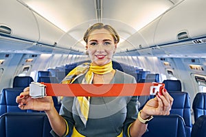 Smiling stewardess standing in the cabin aisle