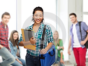 Smiling student with folders, tablet pc and bag