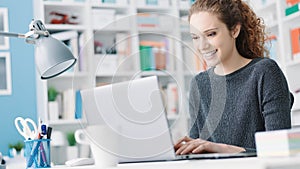 Smiling student girl connecting with a laptop