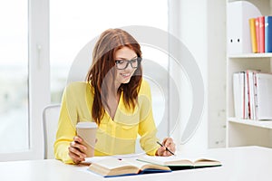Smiling student girl reading books in library