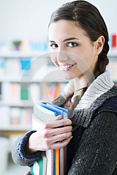 Smiling student holding notebooks