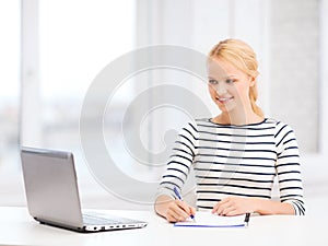 Smiling student with laptop computer and documents