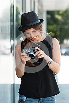 The smiling student photographs with digital mirrorless camera.