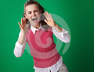 Smiling student woman shouting through megaphone shaped hands