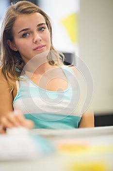 Smiling student working in the computer room looking at camera