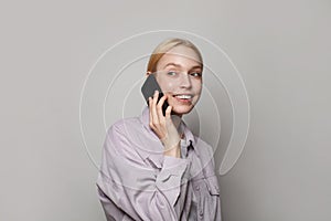 Smiling student young woman wearing casual clothes talking on phone against white studio wall banner background