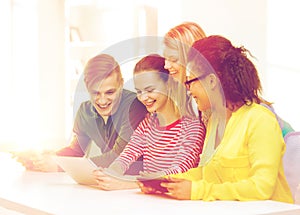 Smiling students looking at tablet pc at school