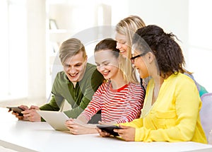 Smiling students looking at tablet pc at school