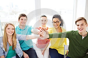 Smiling students making high five gesture sitting