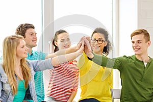 Smiling students making high five gesture sitting
