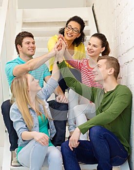 Smiling students making high five gesture sitting