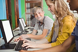 Smiling students studying in computer classroom