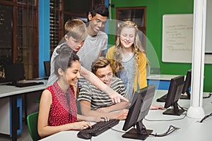 Smiling students studying in computer classroom