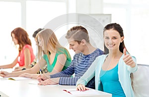 Smiling students with textbooks at school