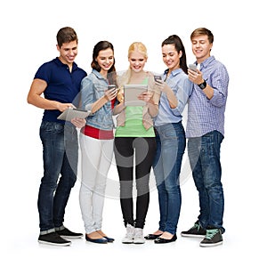 Smiling students using smartphones and tablet pc