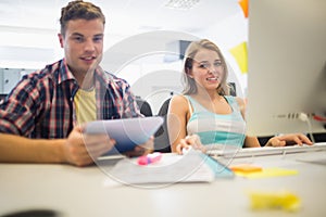 Smiling students working together in the computer room