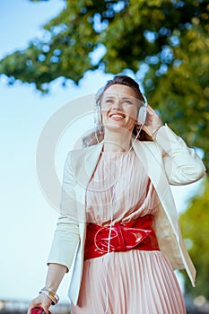smiling stylish 40 years old woman in dress and jacket in city