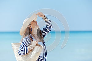 smiling stylish 40 years old woman on seashore having fun time