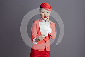 smiling stylish asian female air hostess against grey