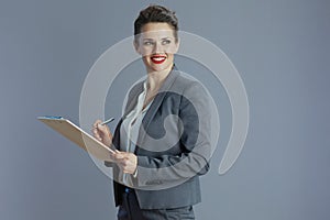 smiling stylish business woman against grey background