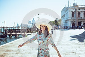 smiling stylish woman in floral dress exploring attractions