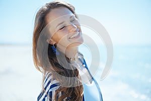 smiling stylish woman on ocean shore enjoying tranquility