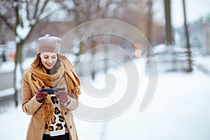 smiling stylish woman sending text message using smartphone