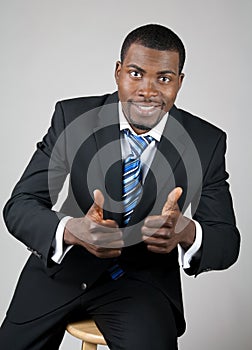 Smiling successful businessman with thumbs up