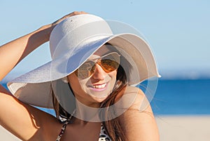 Smiling summer woman with sunglasses and floppy hat