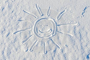 Smiling sun drawn on the surface of the snow