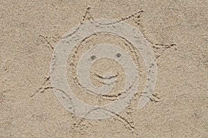 Smiling sun on sand drawing