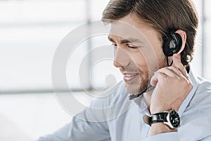 smiling support hotline worker in headphones with microphone