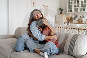 Smiling supportive young mother hugging cuddling teen daughter, mom parent supporting teenage girl