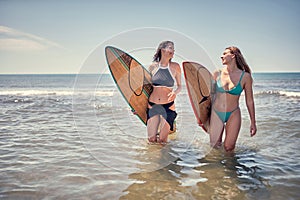 Smiling Surfer girl walking with board on the sandy beach. Surfer girl. Beautiful young woman at the beach. water sports. .