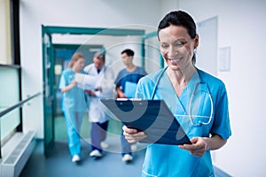 Smiling surgeon holding a clipboard at hospital