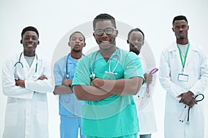 Smiling surgeon standing in front of his colleagues