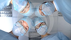 Smiling surgeon team faces, pov patient waking up after operation anesthesia