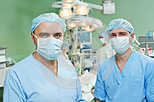 Smiling surgeons team at cardiac surgery operation