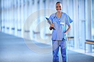 Smiling after surgery. Portrait of a young female doctor holding a patients chart.