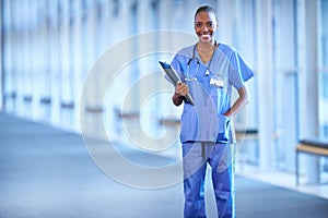 Smiling after surgery. Portrait of a young female doctor holding a patients chart.